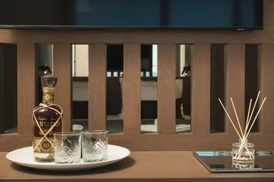 a bottle of whiskey and two glasses on a table at Elia Agia Marina Resort in Agia Marina Nea Kydonias