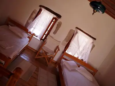 a room with two beds and a bed and a window at Small traditional house in Douliana