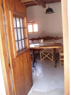 a room with a wooden door and a table at Small traditional house in Douliana