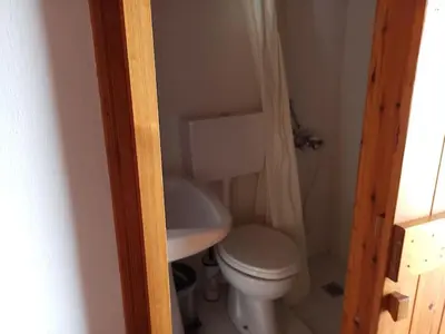a small bathroom with a toilet and a sink at Small traditional house in Douliana