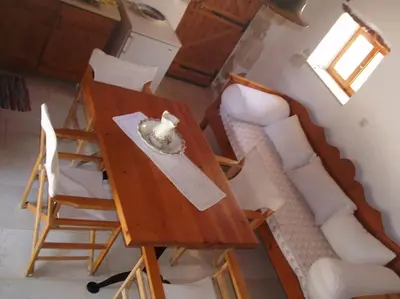 a room with a table and chairs and a couch at Small traditional house in Douliana