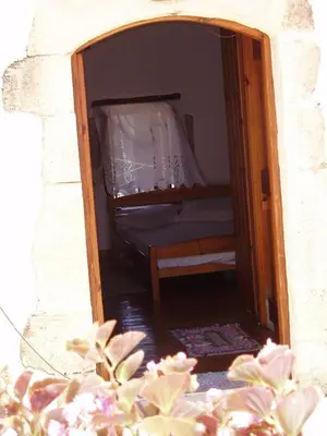 a door to a bedroom with a bed in it at Small traditional house in Douliana