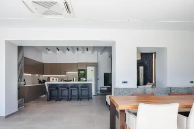 an open kitchen and dining room with a wooden table at Casa del Balo in Gavalomoúrion