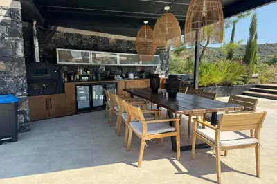 an outdoor dining room with a wooden table and chairs at Casa del Balo in Gavalomoúrion