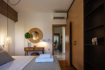 a bedroom with a bed and a table and a mirror at JW luxury apartment in Chania Town