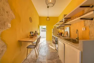 a kitchen with yellow walls and a wooden table at Mourelo Home in Gavalochori