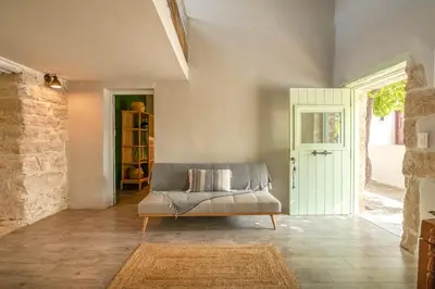 a living room with a couch and a door at Mourelo Home in Gavalochori