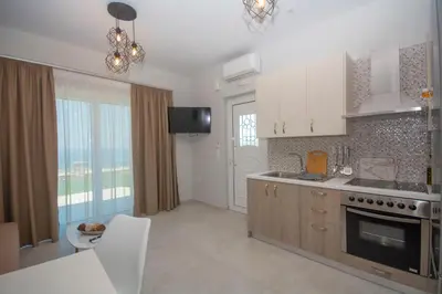 a kitchen with a sink and a stove top oven at Korfali Apartments in Kissamos