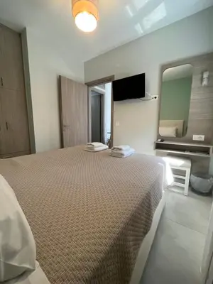 a bedroom with a large bed and a mirror at Korfali Apartments in Kissamos