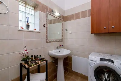 a bathroom with a washing machine and a sink at Seaside Escape in Nopíyia