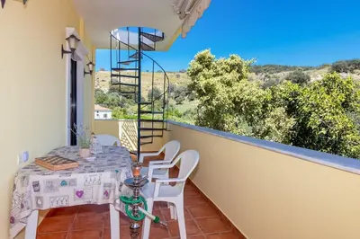 a dining room with a table and chairs on a balcony at Seaside Escape in Nopíyia
