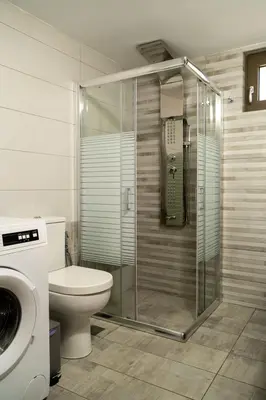 a bathroom with a toilet and a glass shower stall at Villa Emily in countryside in Chania Town