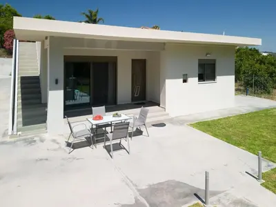 a small white house with a table and chairs at Villa Emily in countryside in Chania Town