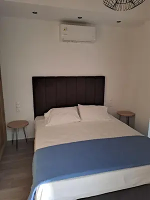 a bedroom with a large bed with two tables at Parthenon apartment in Souda