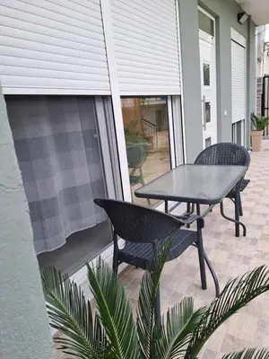 a patio with a table and chairs on a balcony at Parthenon apartment in Souda