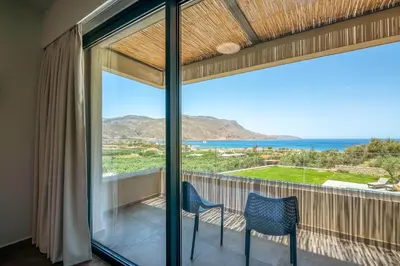 a balcony with two chairs and a view of the ocean at Nusa Retreat - Seaview luxury residences - ideal for groups in Kissamos