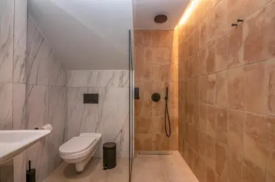 a bathroom with a shower with a toilet and a sink at Nusa Retreat - Seaview luxury residences - ideal for groups in Kissamos