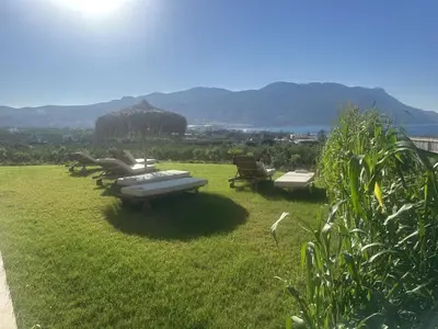 a group of chaise lounges and chairs on a lawn at Nusa Retreat - Seaview luxury residences - ideal for groups in Kissamos