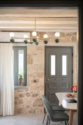 a dining room with a table and a stone wall at La Canea Living in Chania Town