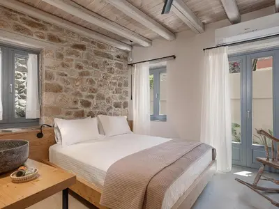 a bedroom with a bed and a stone wall at La Canea Living in Chania Town