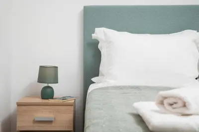 a bedroom with a bed and a night stand with a lamp at Somine Apartment Chania in Chania Town