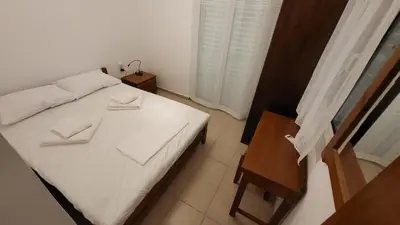 a bedroom with a white bed with two towels on it at Villa Alex in Tavronitis
