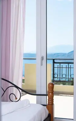 a bedroom with a bed and a view of a balcony at Souda Bay View with Private Pool near Chania City in Chania Town