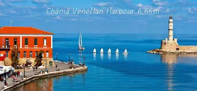 a lighthouse on the water with sailboats in the water at Souda Bay View with Private Pool near Chania City in Chania Town