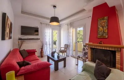 a living room with a red couch and a fireplace at Souda Bay View with Private Pool near Chania City in Chania Town