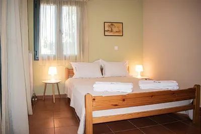 a bedroom with a large bed with two lamps at glarosmaisonette in Kato Daratso