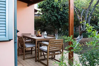 a wooden table and chairs on a patio at glarosmaisonette in Kato Daratso