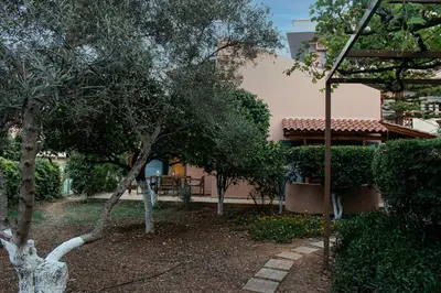 a garden with trees in front of a house at glarosmaisonette in Kato Daratso