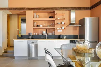 a kitchen with white cabinets and a table with chairs at Boutique house Romantza in Kallithea-Voukolies