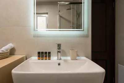 a white sink in a bathroom with a mirror at Casa Del Sol-Halepa- in Chania Town