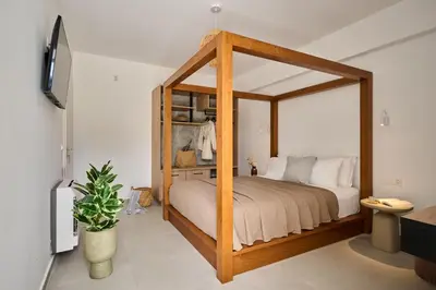 a bedroom with a wooden canopy bed with white pillows at Kyamon Luxury Villa with Heated Saltwater Pool Near Chania in Chania Town