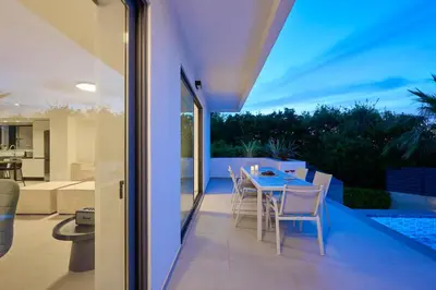 a patio with a table and chairs on a balcony at Kyamon Luxury Villa with Heated Saltwater Pool Near Chania in Chania Town