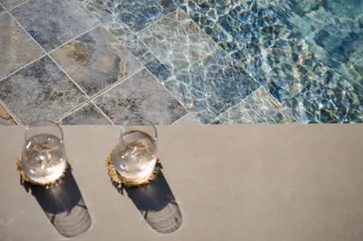 a pair of shoes sitting next to a swimming pool at Kyamon Luxury Villa with Heated Saltwater Pool Near Chania in Chania Town
