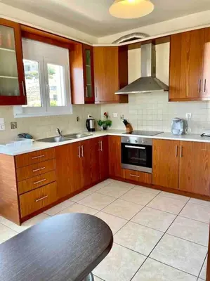 a kitchen with wooden cabinets and a stove top oven at Sea View Apartment #2 in Stalos