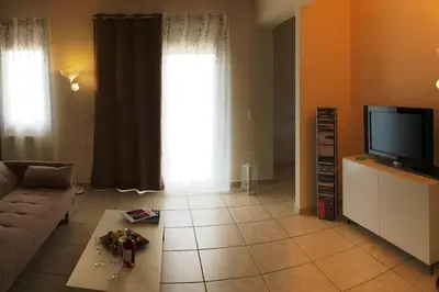 a living room with a couch and a television at Sea View Apartment #2 in Stalos