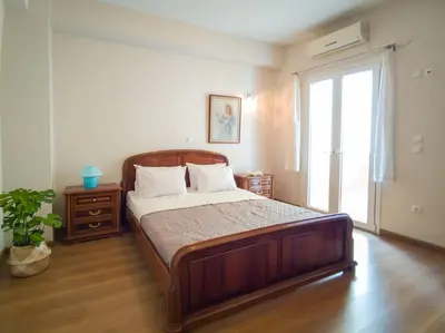 a bedroom with a large wooden bed and a window at Kadiani's Residence by 8essentially in Chania Town