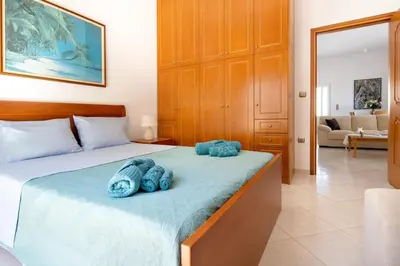 a bedroom with a bed with blue towels on it at Iconic Villa with private pool and sea view in Próvarma