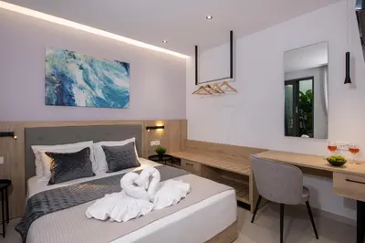 a bedroom with a bed with swans towels on it at Cretan Queen Residences in Aghii Apostoli