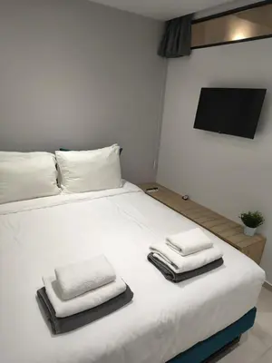 a bedroom with a white bed with towels on it at Cretan Queen Residences in Aghii Apostoli