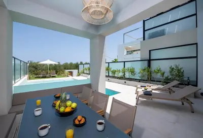 an image of a living room with a table and chairs at Cretan Queen Residences in Aghii Apostoli