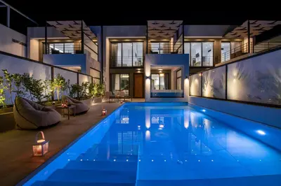 a house with a swimming pool at night at Cretan Queen Residences in Aghii Apostoli