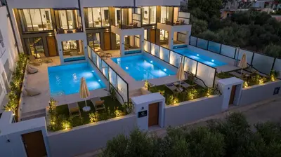 an aerial view of a building with a pool at night at Cretan Queen Residences in Aghii Apostoli