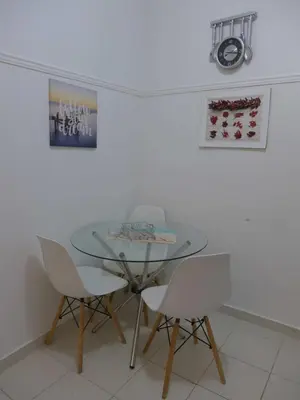 a dining room with a glass table and white chairs at Koum Kapi 1st floor apt in Chania Town