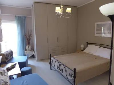 a bedroom with a large bed and a chandelier at Koum Kapi 1st floor apt in Chania Town