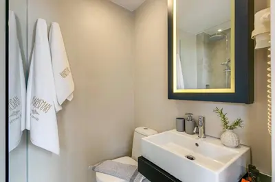 a bathroom with a sink and a toilet and a mirror at Harismari Cozy Hotel in Chania Town