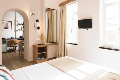 a bedroom with a bed and a desk and a mirror at Harismari Cozy Hotel in Chania Town